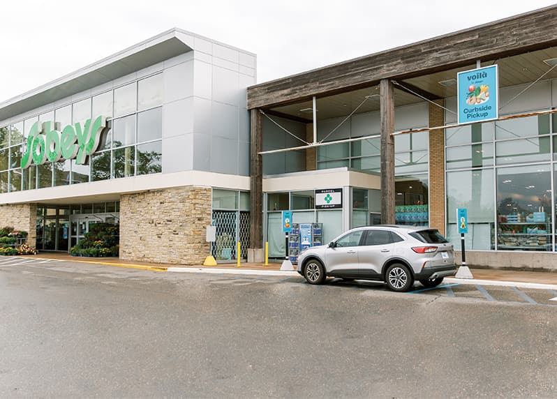 An image representing customer parked in designated parking spot to pick up their Voilà by Sobeys Curbside Pickup grocery order.