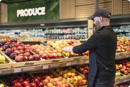 An image of a Sobeys teammate arranging fruits and vegetables in the grocery store.