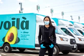 Outside the Customer Fulfilment Centre in Vaughan, ON, Sarah Joyce, Senior Vice President of E-commerce, stands in front of the Voilà by Sobeys fleet.