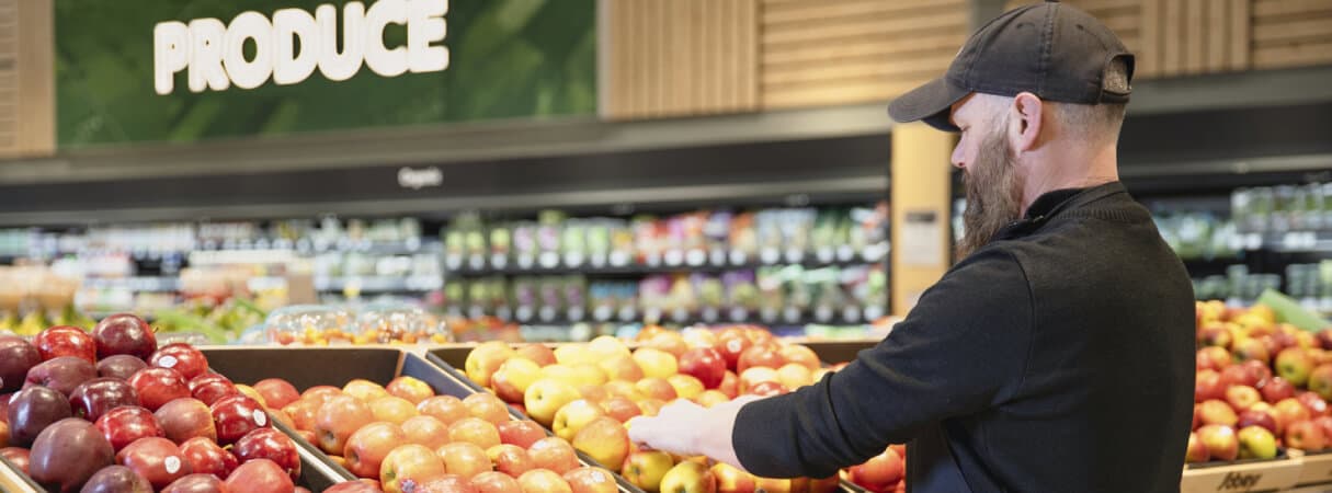 An image of a Sobeys teammate arranging fruits and vegetables in the grocery store.