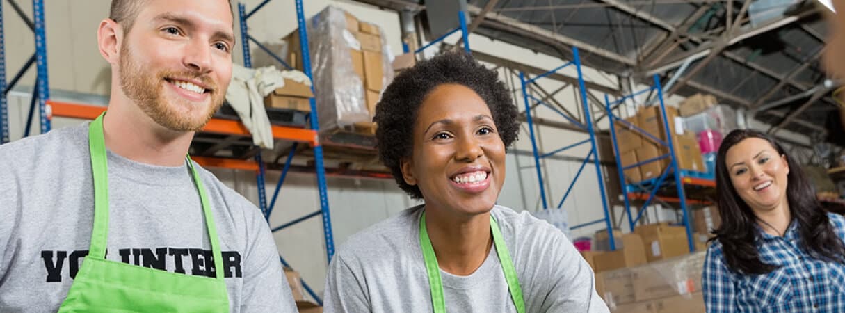 An image of a man and a woman smiling and attending customers.