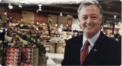 Image of a person displaying a man with lots of vegetables behind him.